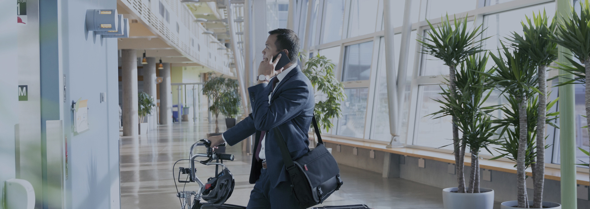 man talking on phone while holding bicycle