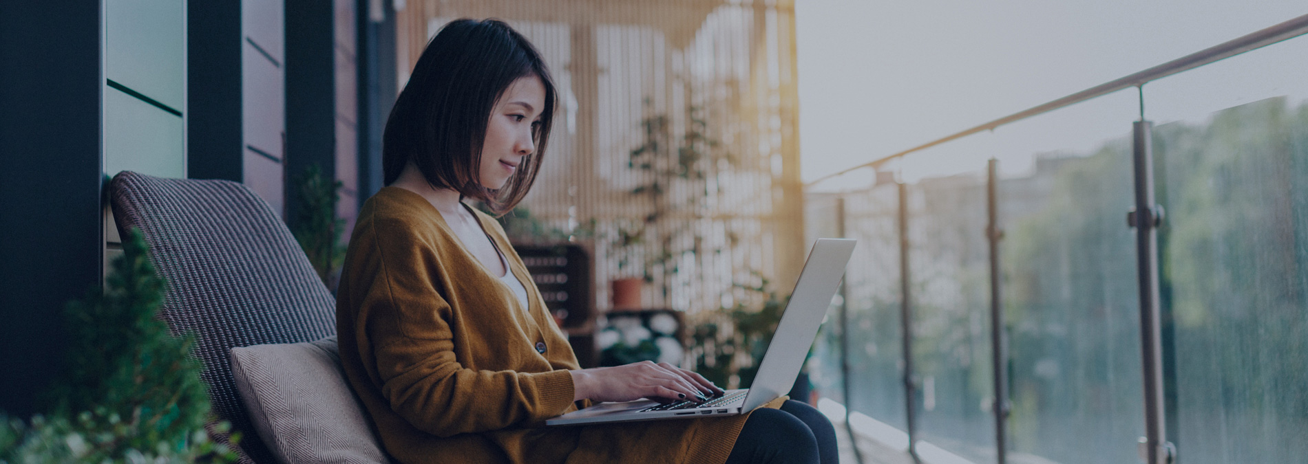 woman working on laptop in balcony